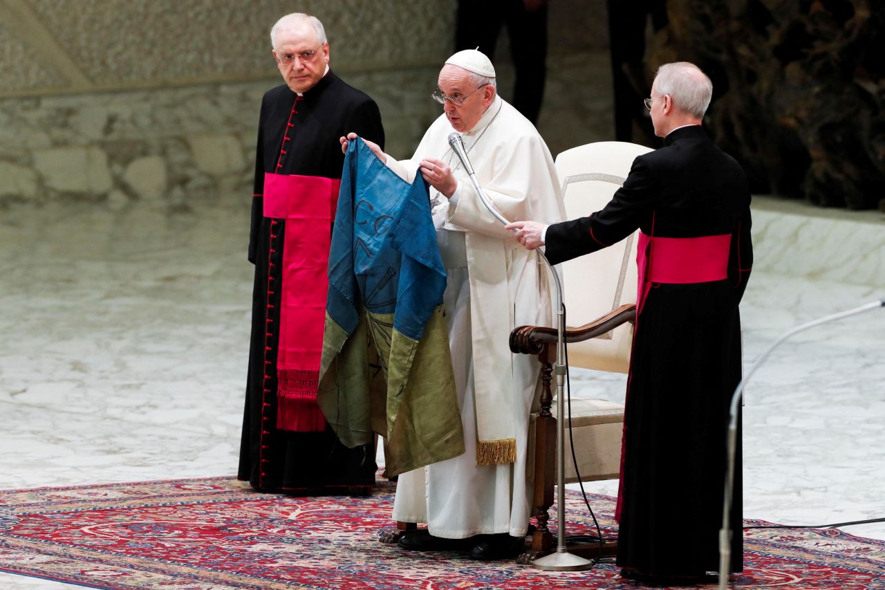 Pope Francis holds the Ukrainian flag that was sent to him from the town of Bucha during the weekly general audience at the Paul VI Hall at the Vatican on April 6.