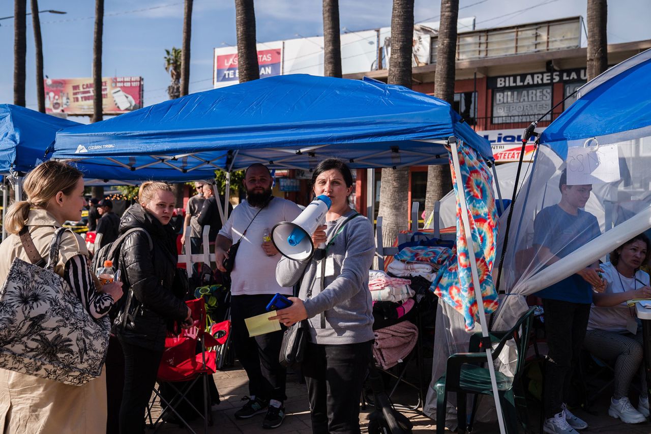 A volunteer calls out numbers at a makeshift camp where Ukrainians are staying to hold their place in line near the San Ysidro Port of Entry in Tijuana, Mexico, on Monday.