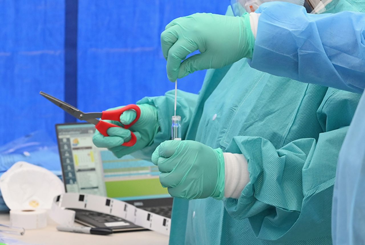 Healthcare workers place a nasal swab from a patient into a tube for testing at the Brightpoint Health and UJA of NY Federation free pop-up coronavirus testing site on Friday, May 8, in Brooklyn, New York City. 