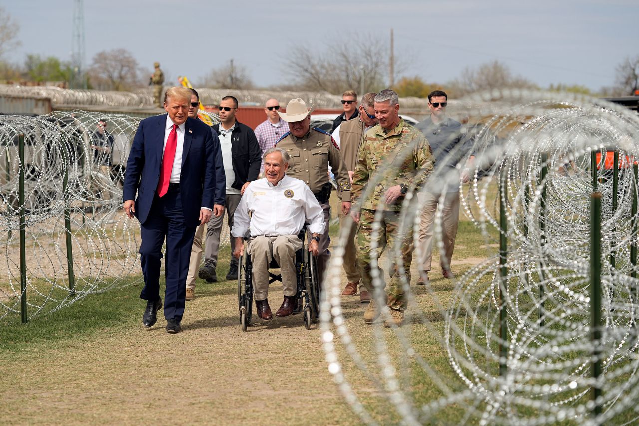 Former President Donald Trump talks with Texas Gov. Greg Abbott during a visit to the US-Mexico border on Thursday in Eagle Pass, Texas.