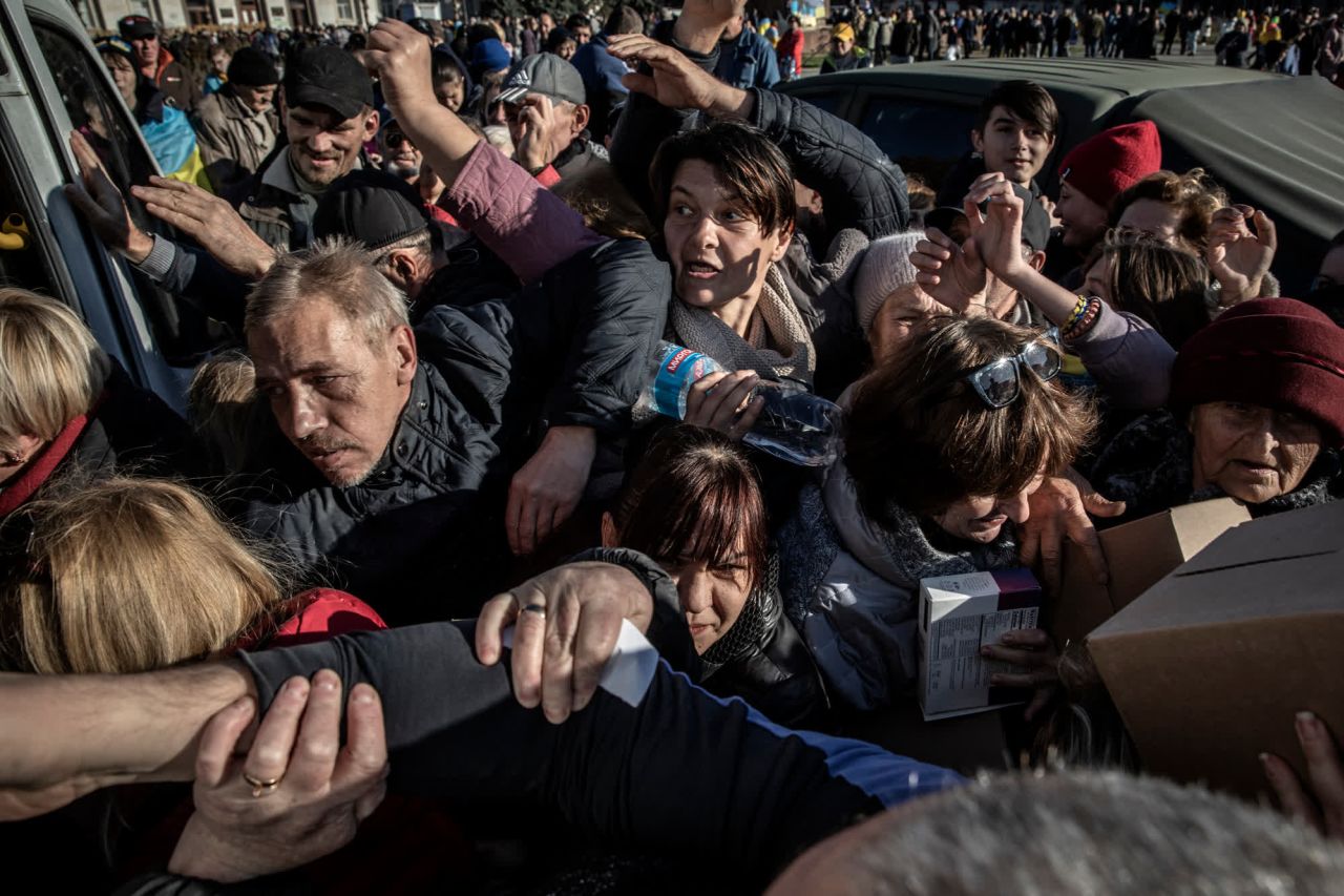 Ukrainians jostle for food handouts in Kherson.