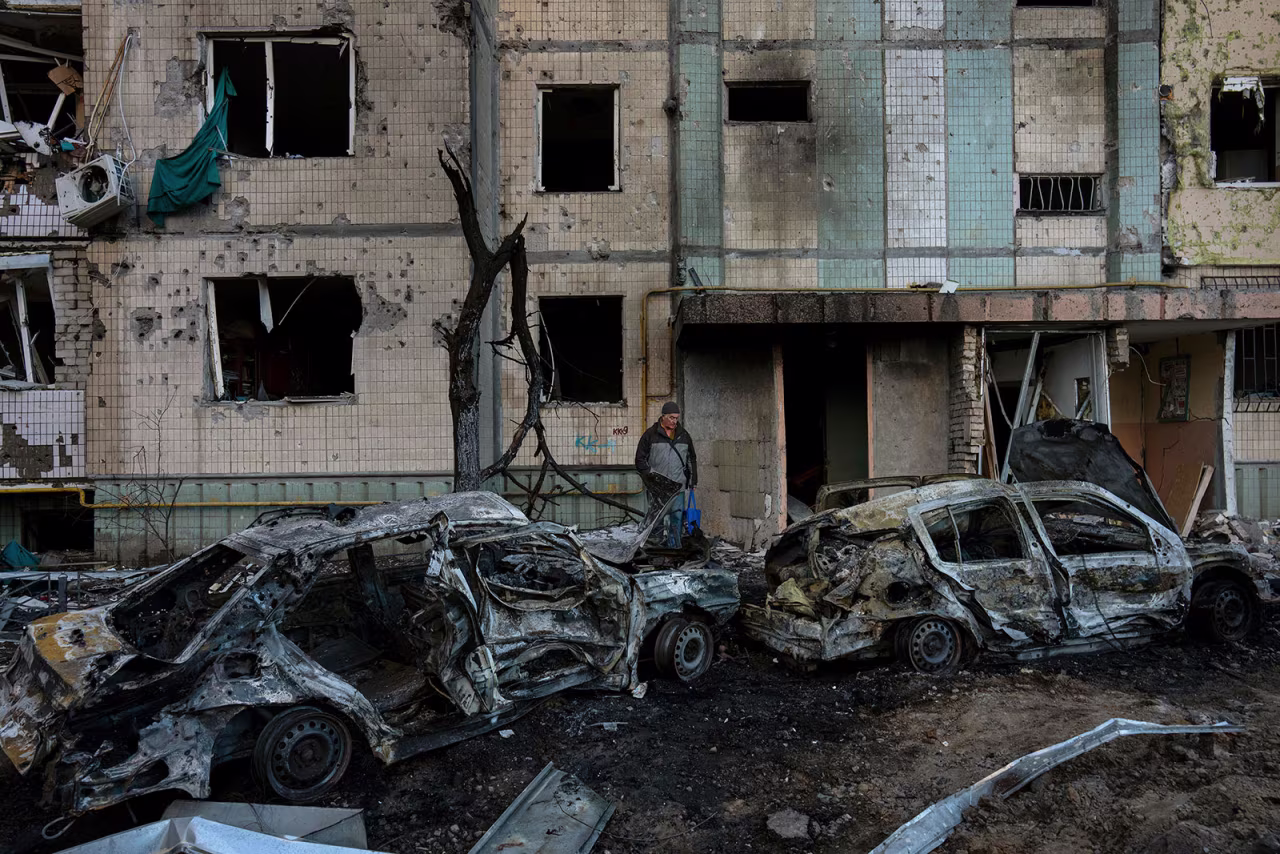 A neighbor stands amid the destruction caused by a bomb in the Satoya neighborhood in Kyiv on Sunday, March 20. 