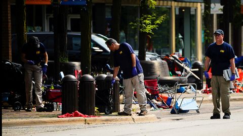 FBI agents investigate the scene on Tuesday, July 5, a day after the shooting in Highland Park, Illinois.