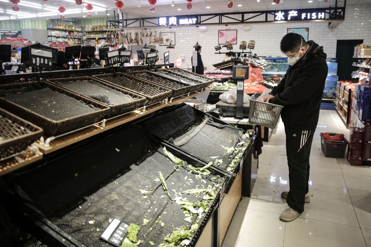 A resident wearing a mask shops for vegetables in Wuhan on January 23. Getty Images