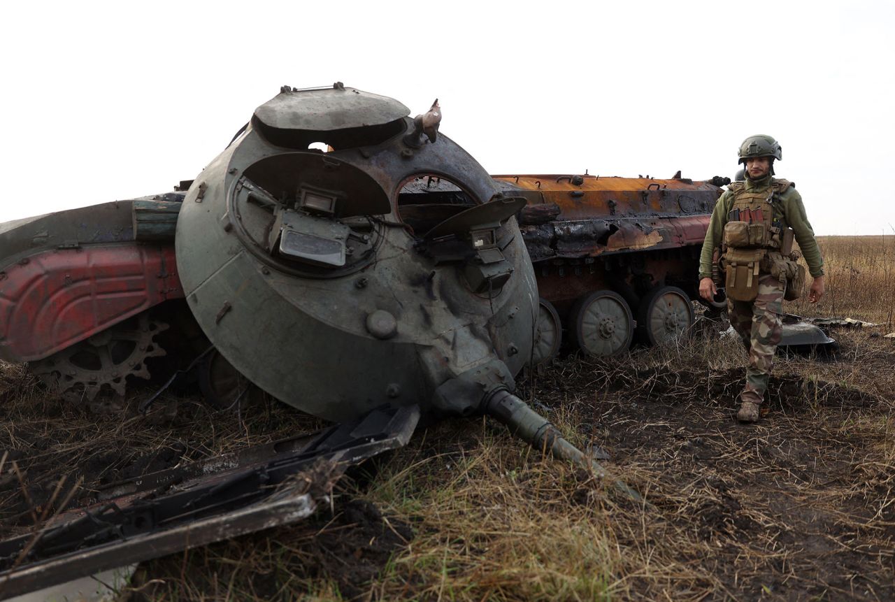 A Ukrainian soldier walks past a destroyed Russian tank on the front line with Russian troops in the Donetsk region on September 28.
