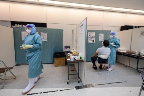 A medical worker collects a nasal swab from an arrival passenger to test for Covid-19 at a polymerase chain reaction (PCR) testing site in Narita, Chiba Prefecture, Japan, on Sunday, July 19, 2020.