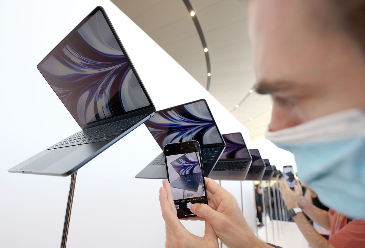 An attendee takes a picture of a newly redesigned MacBook Air laptop displayed during the WWDC22 at Apple Park on June 6 in Cupertino, California.?