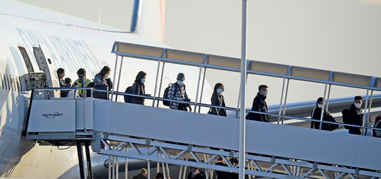 Travelers wearing masks exit off of China Airlines flight 24 at Ontario International Airport after arriving from Taipei, Taiwan Tuesday January 28. 