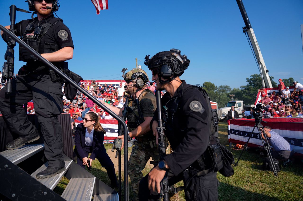 Secret Service agents rush the stage. 