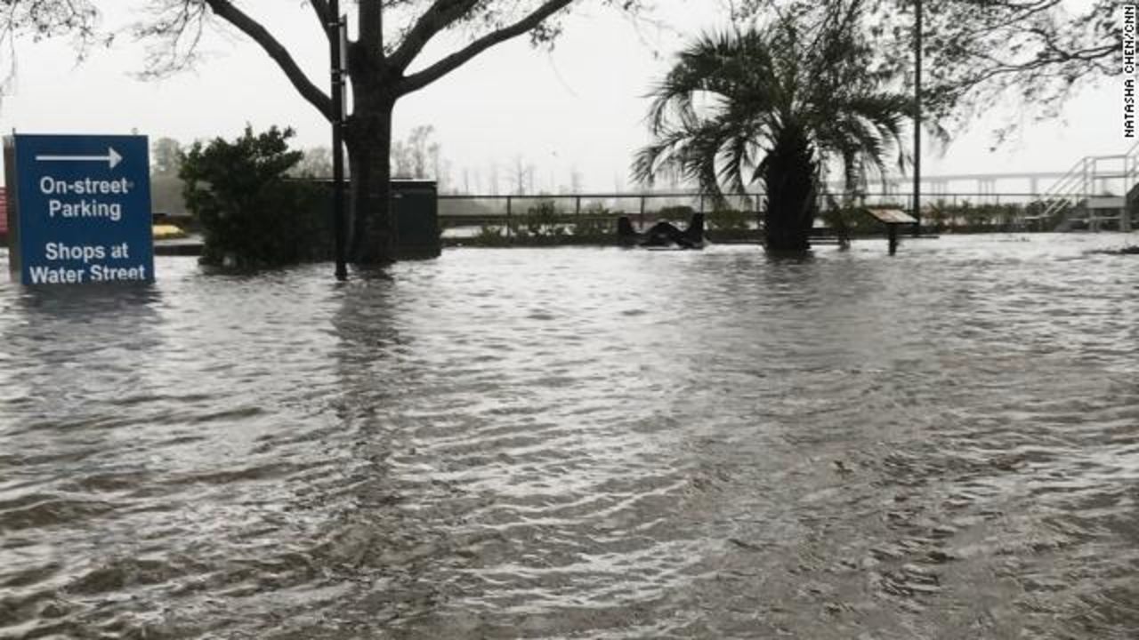 An area in downtown Wilmington, North Carolina, usually meant for street parking and relaxing on park benches is inundated by water from the swollen Cape Fear River.