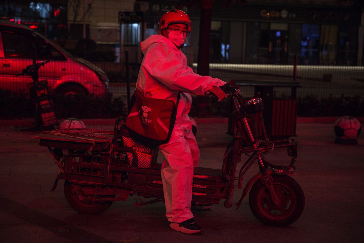 A delivery driver wears a protective mask and suit as he delivers packages on Saturday in Wuhan.