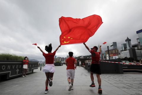 Supporters pose with Chinese and Hong Kong flags at the Convention Avenue, on the 25th anniversary of the former British colony's handover to Chinese rule, in Hong Kong on July 1.