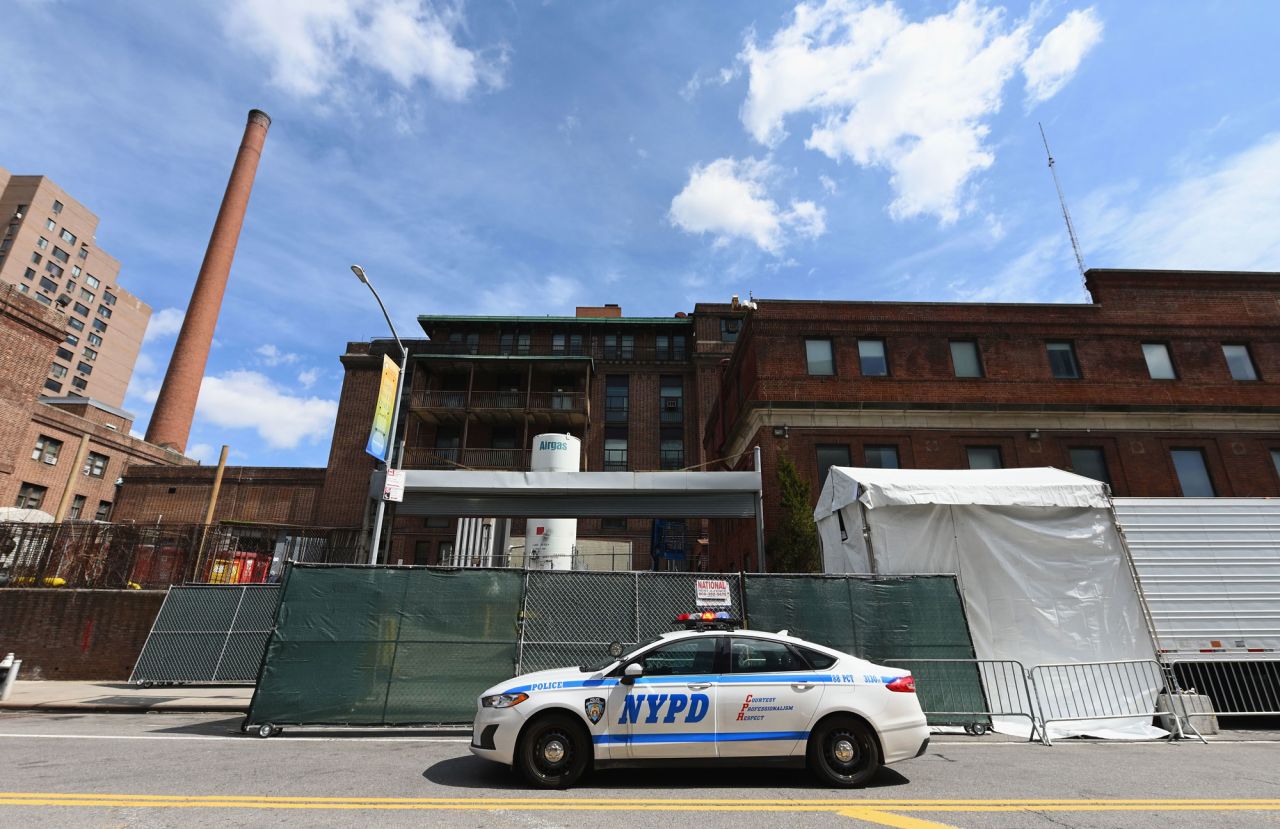 A NYPD car is parked in front of a refrigerated truck?outside of the Brooklyn Hospital on April 1, in New York City.