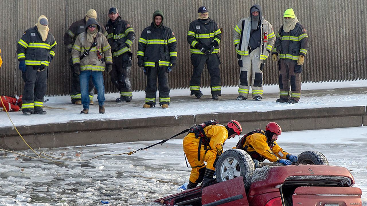 Kansas City fire department rescue personnel work to recover a minivan that went into Brush Creek in Kansas City, Missouri, on Thursday, December 22.
