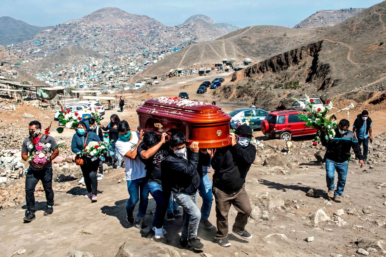 People carry the coffin of a suspected coronavirus victim at the Nueva Esperanza cemetery, on the southern outskirts of Lima, Peru, on Saturday, May 30.