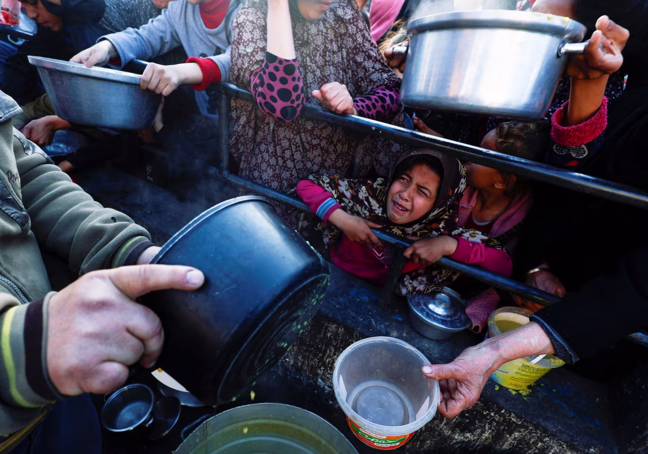 A child reacts as Palestinians wait to receive food in Rafah, southern Gaza on March 13.