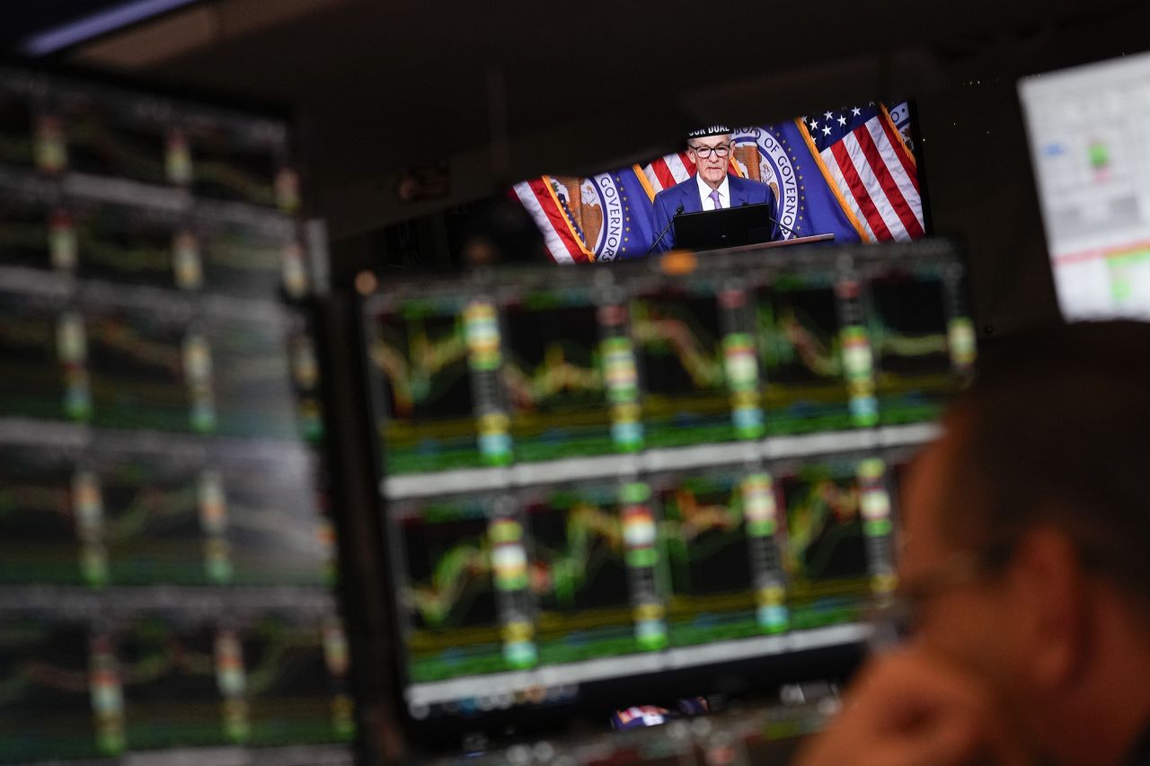 A screen displays a news conference with Federal Reserve Chairman Jerome Powell as traders work on the floor at the New York Stock Exchange on May 1.