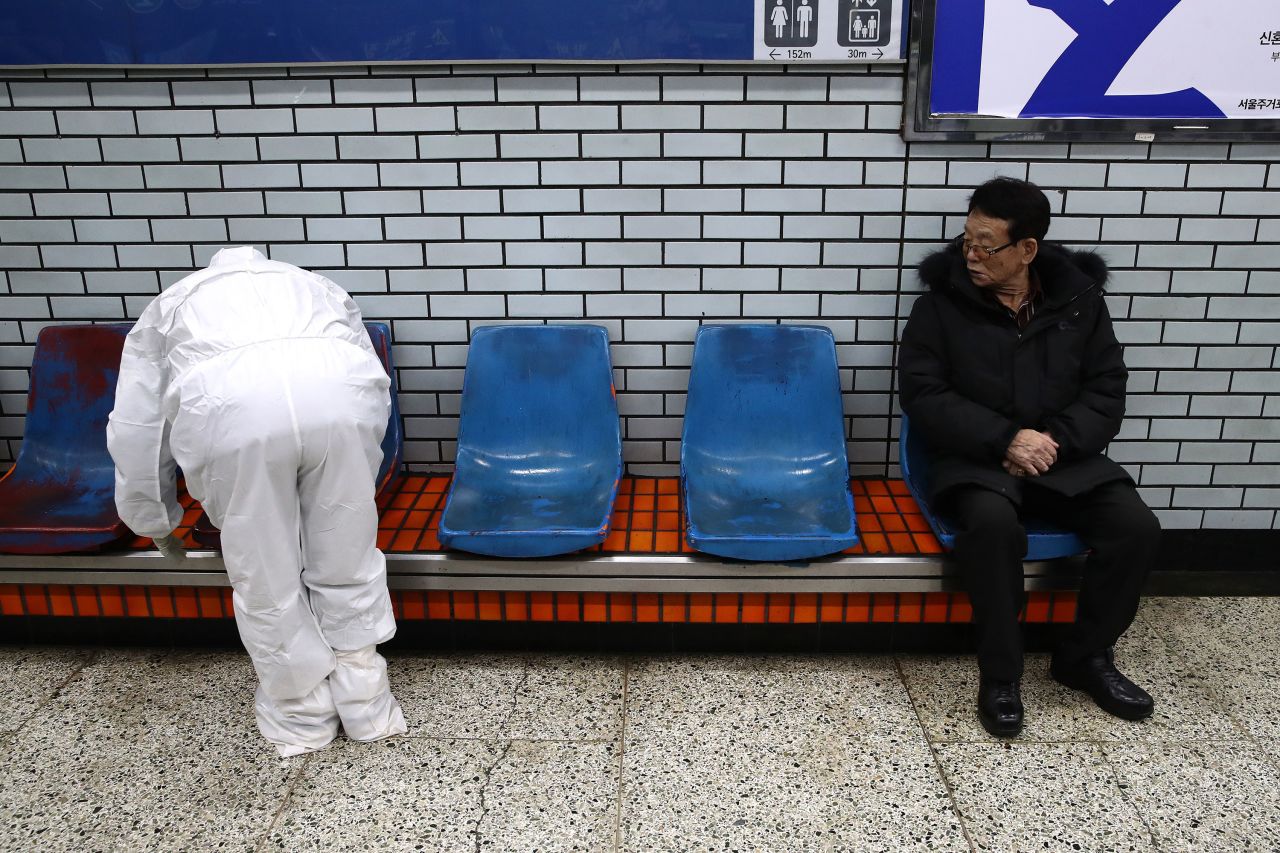 An official in protective clothing sprays disinfectant in a subway station in Seoul.