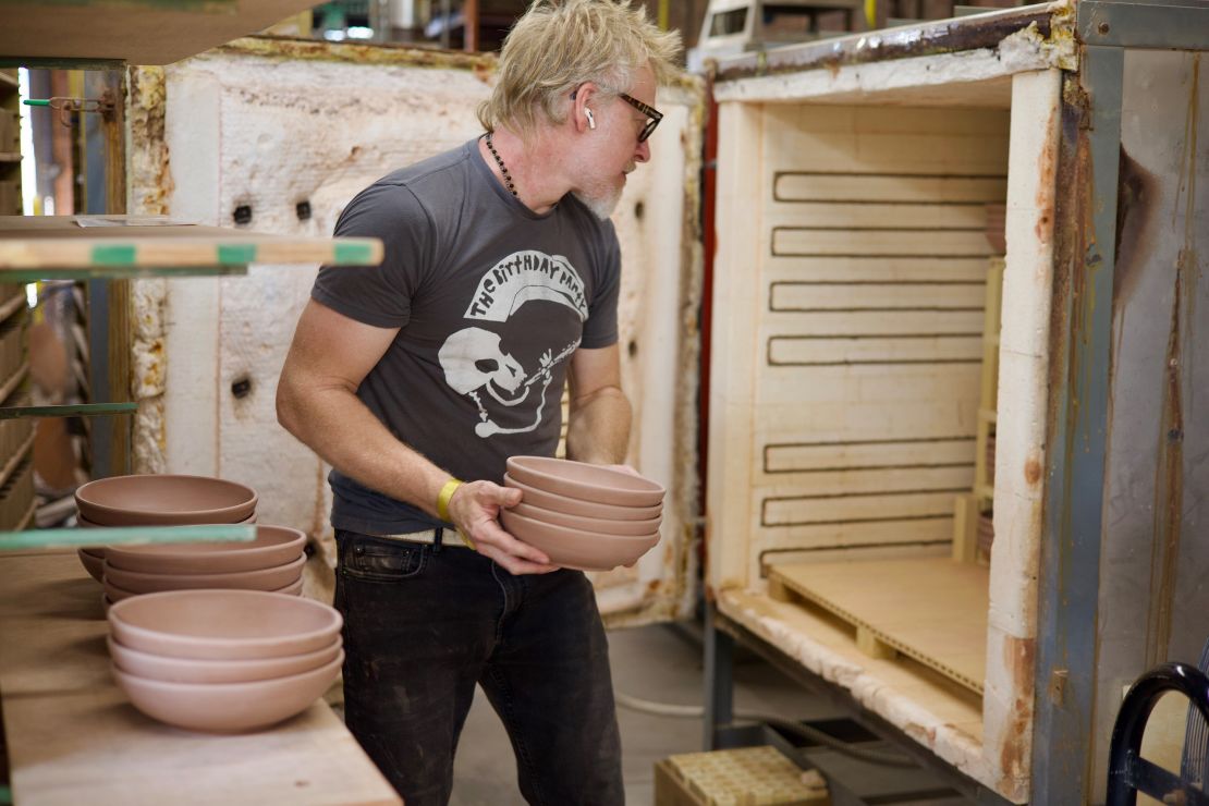 A potter places bowls into the gas-fired kiln at East Fork Pottery's Asheville factory.