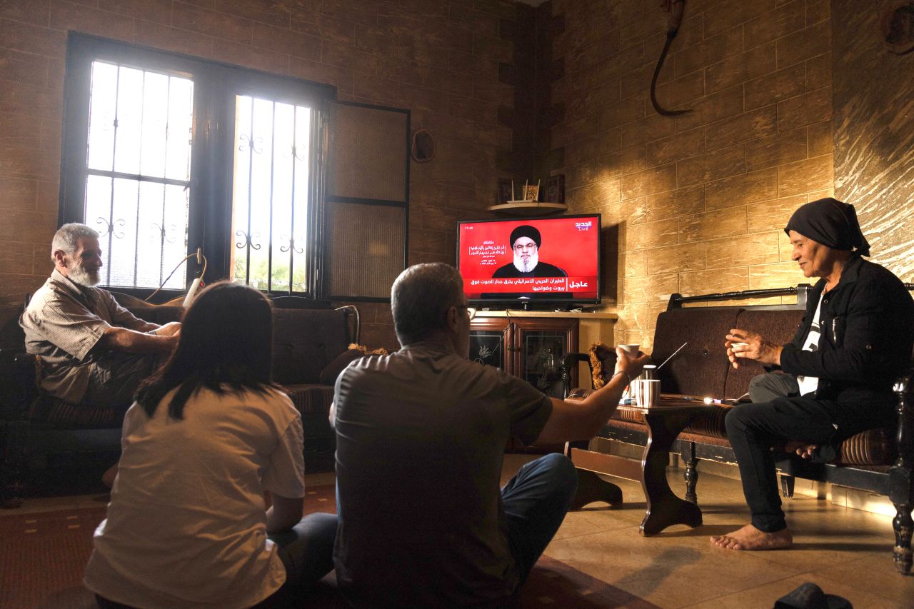 People watch a televised speech by the leader of the Hezbollah movement Hassan Nasrallah inside a house in the southern Lebanese village of Zawatar on September 19.