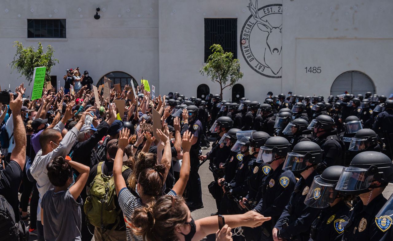 Demonstrators gather in front of police officers in downtown San Diego, California, on May 31.