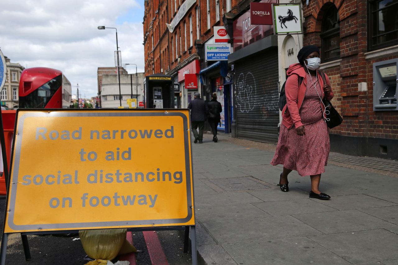 A sign is pictured explaining that the road has been narrowed to aid social distancing when using Camden High Street in central London on May 11.