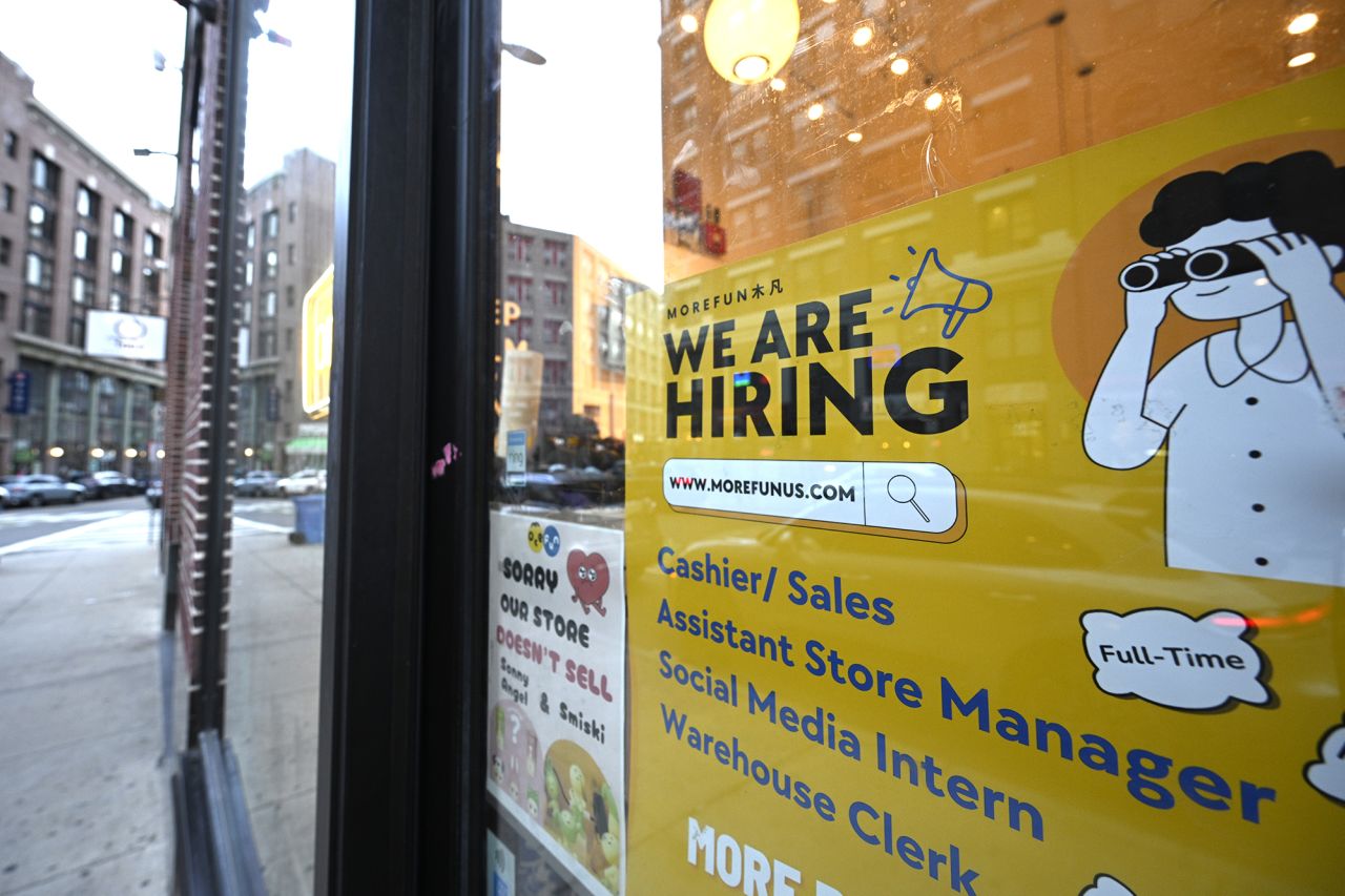 A We Are Hiring sign advertising job openings is viewed outside of a store on July 10 in Boston. 