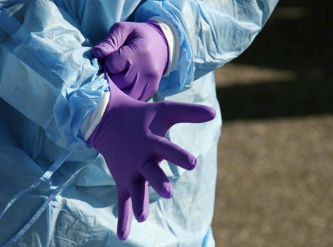 A health care worker prepares to tend to patients at a drive-in testing center in Jericho, New York, on March 18.