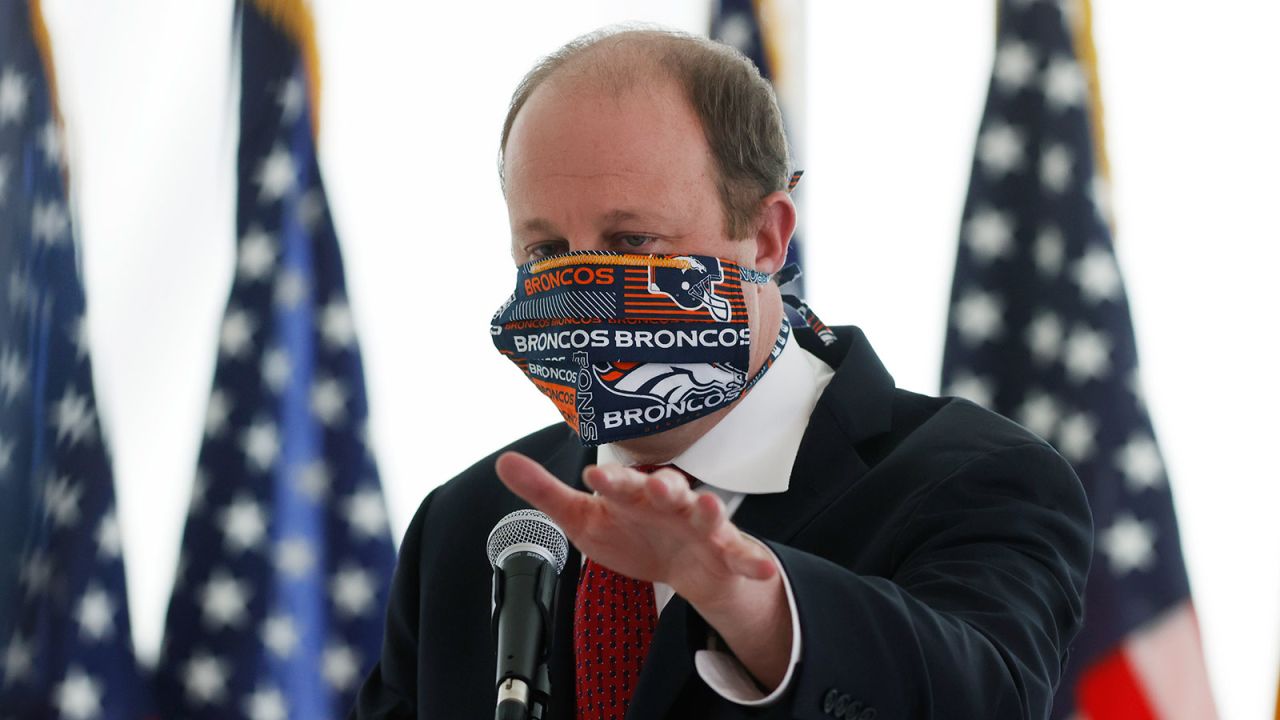 Colorado Governor Jared Polis wears a face mask as he answers a question during a news conference to update the state's efforts to stop the spread of the new coronavirus in Denver, Colorado on April 22.