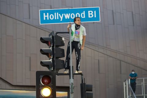 A demonstrator shouts slogans after climbing on a traffic light on June 7, in the Hollywood area of Los Angeles.