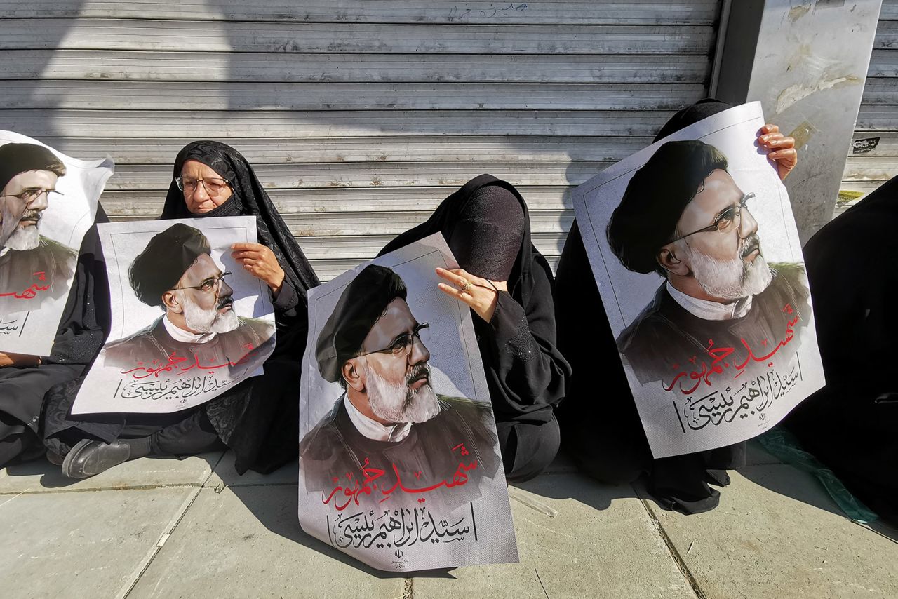 Mourners hold posters of Iranian President Ebrahim Raisi during a funeral ceremony in Tehran for him and others who were killed in a helicopter crash. 