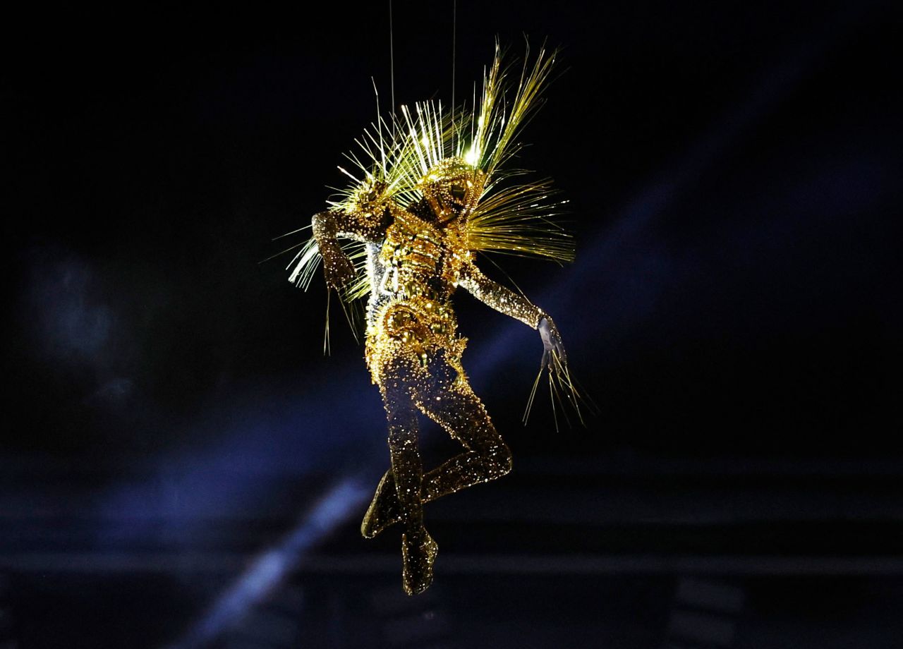 A golden figure is lowered from the roof. 