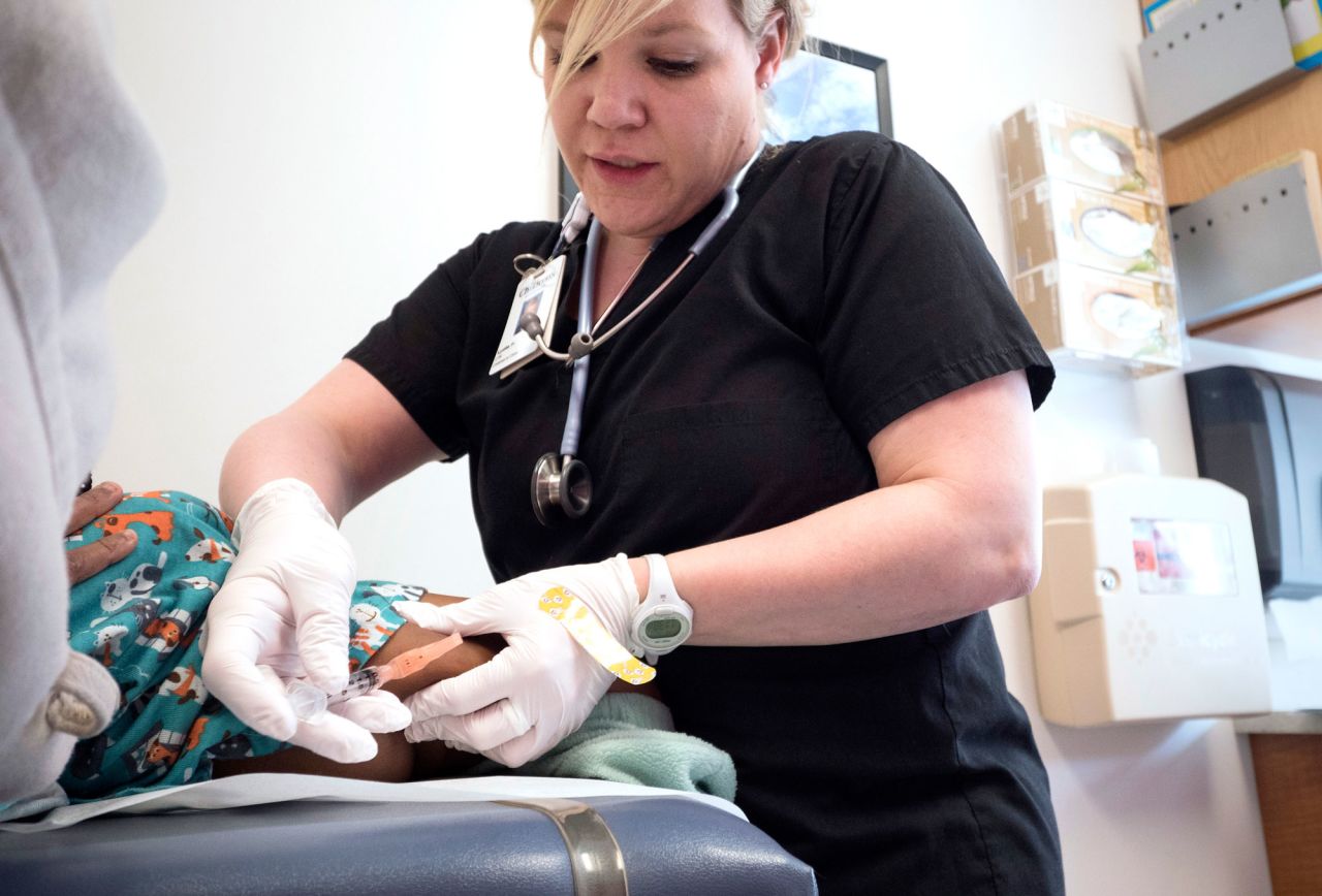 Lydia Fulton, LPN, administers the MMR vaccine to a child at Children's Primary Care Clinic in Minneapolis, on April 28, 2017. 