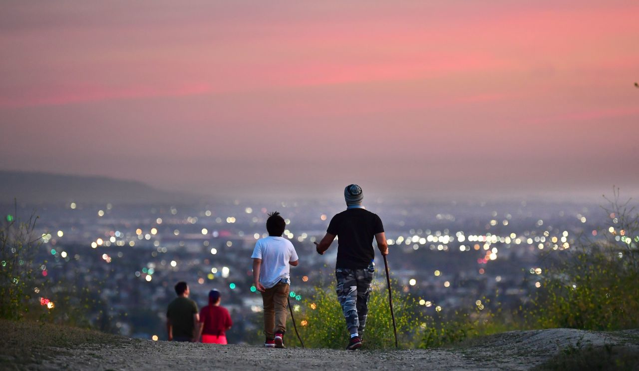 People hike on a trail at dusk in Los Angeles on May 7.