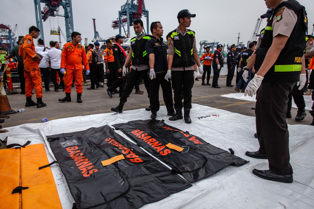 Indonesian police prepare to carry body bags containing remains of a passenger as they recover bodies and personal items from Lion Air flight JT 610 at the Tanjung Priok port Tuesday in Jakarta.