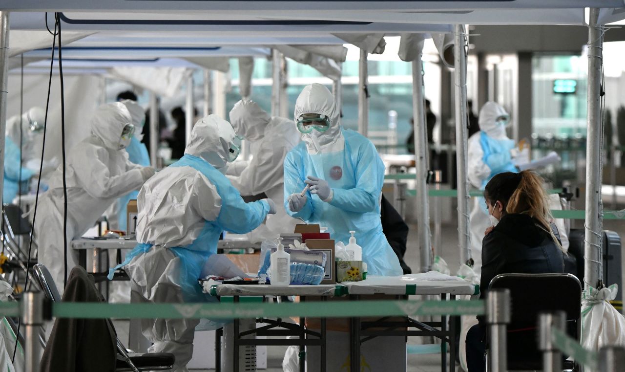 Medical workers administer coronavirus tests at a testing booth outside Incheon International Airport, in Incheon, South Korea, on April 1.