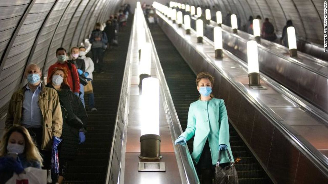 People wear face masks and gloves on a subway escalator in Moscow on Tuesday.