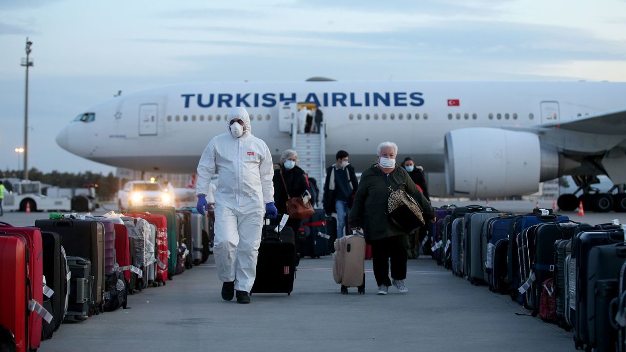 Officials accompany passengers to conduct a health check-up at Esenboga airport in Ankara, Turkey on April 20.