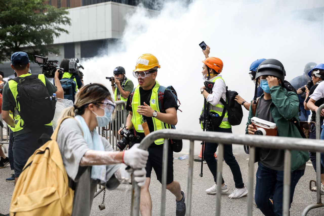 Protesters and members of the media react after police fired tear gas.