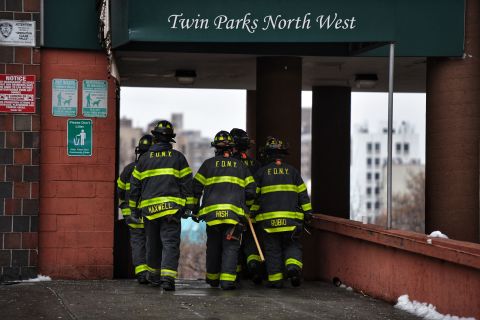 Firefighters work outside an apartment building after a fire in the Bronx, on Sunday. 