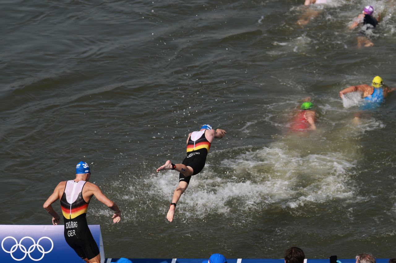 Athletes from Germany dive into the River Seine at the start of the men's triathlon on Wednesday.