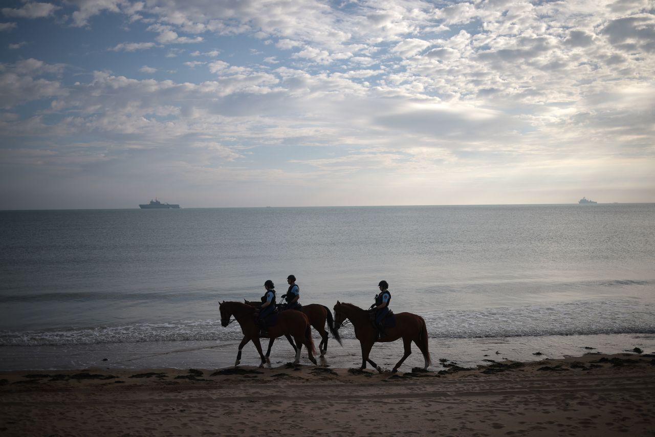 Mounted gendarmes patrol Omaha Beach as the sun rises in advance of the 80th anniversary of the D-Day invasion on June 4, in Vierville-sur-Mer, France. 