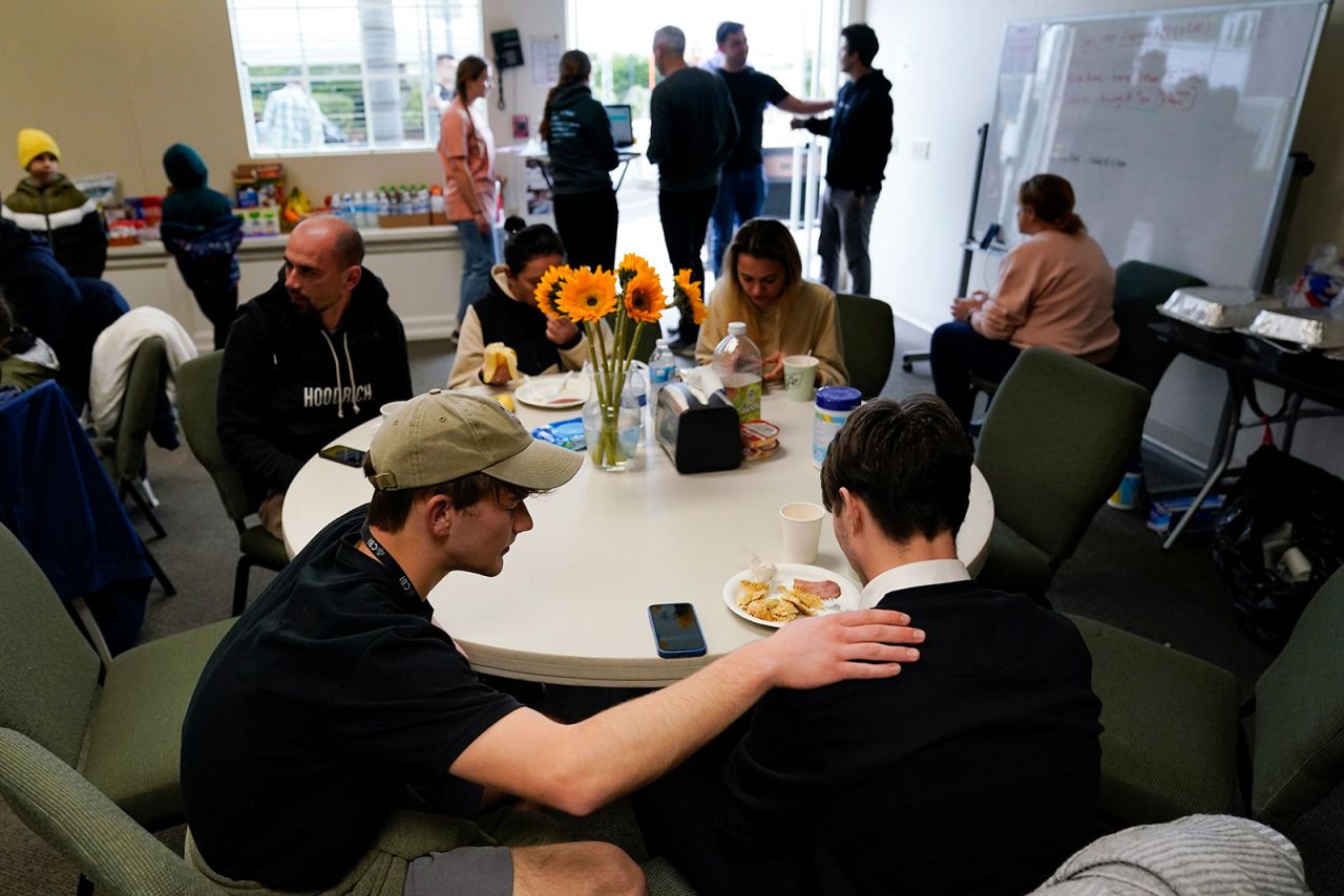 Volunteer Silas Breen, below left, from the Calvary Bible Institute, prays with David, from Ukraine, at Calvary San Diego's shelter for Ukrainians arriving from Tijuana, Mexico, last Friday, in Chula Vista, California.