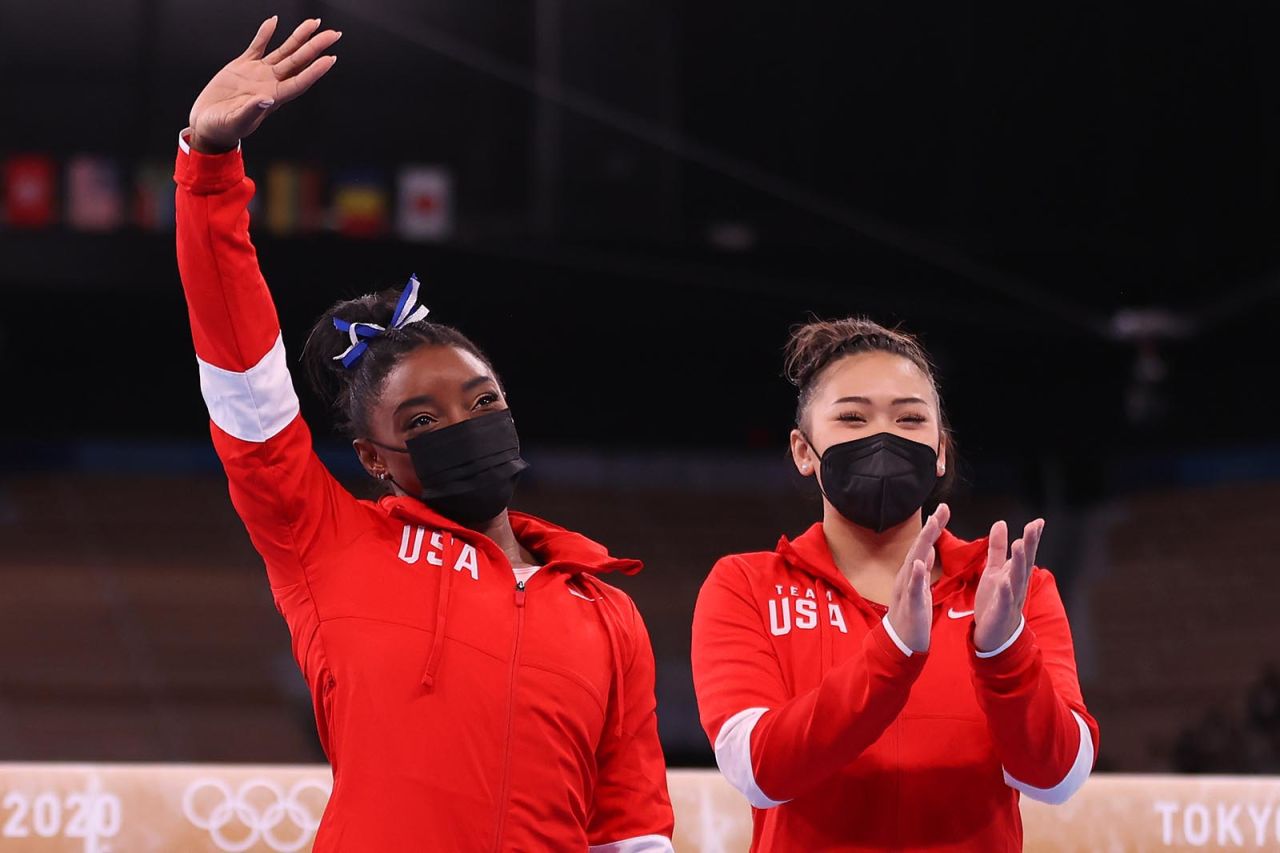 Simone Biles acknowledges the crowd, alongside teammate Sunisa Lee, prior to the women's balance beam final on August 3.