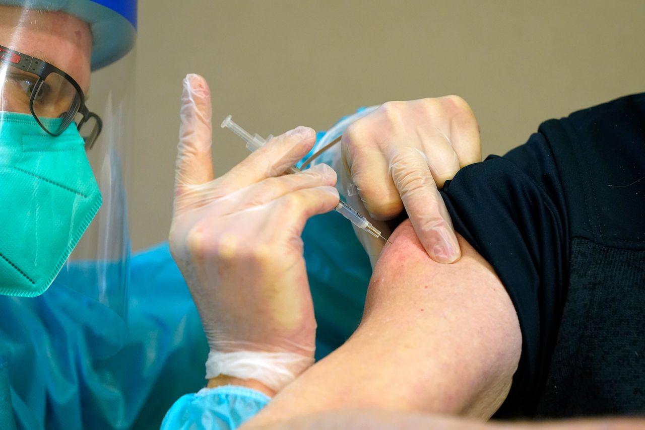 Douglas Magee, 78, a retired Army officer and resident of the Mississippi State Veterans Home in Jackson, right, is inoculated by Brent Myers, a CVS pharmacist, in Jackson, Mississippi, on January 9.