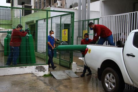 Amazonas Federal University's workers carry empty oxygen tanks at the Getulio Vargas Hospital amid the new coronavirus pandemic, Manaus, Brazil, Thursday, January 14.