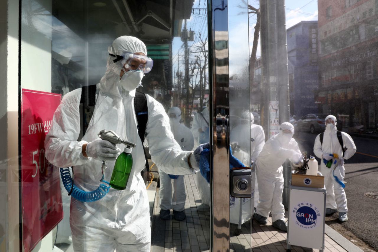 Workers spray antiseptic solution against the coronavirus in Seoul today. 