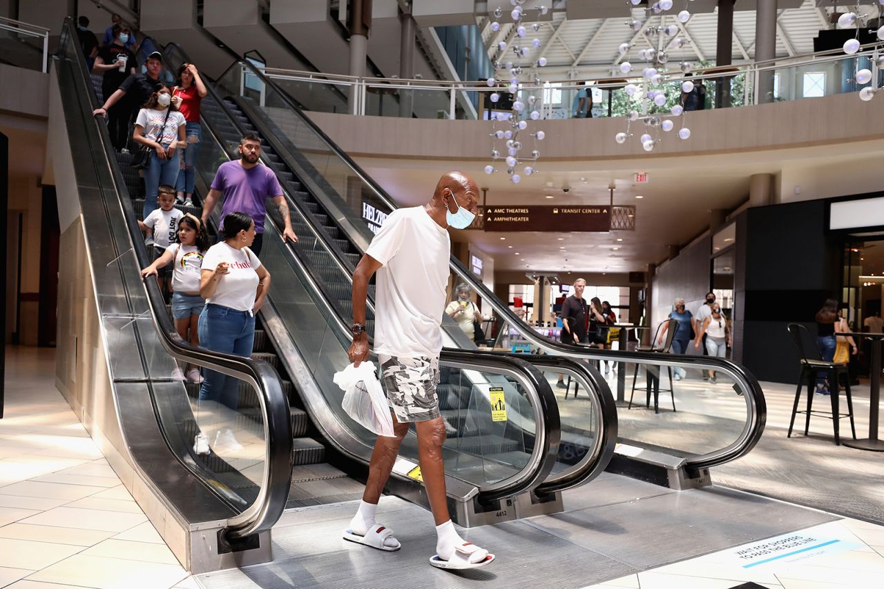 Shoppers exit an escalator as they return to retail shopping at the Arrowhead Towne Center on June 20, in Glendale, Arizona. 