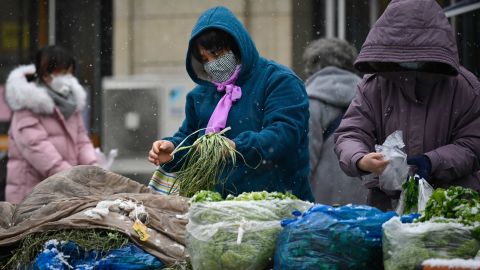 People shop for vegetables at a market in Beijing on February 2. 