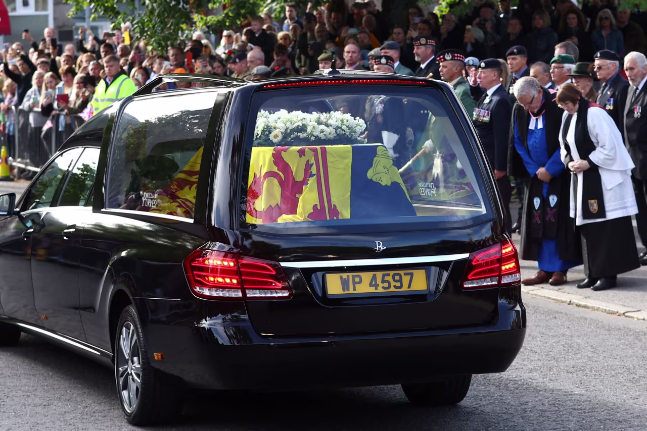 People line the street as the hearse carrying the coffin of Queen Elizabeth II passes through Ballater, Scotland, on September 11. 